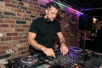 DJ professionnel derrière une table de mixage dans une boîte de nuit, illustrant le métier et les revenus d'un DJ